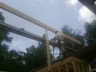 Carpenter setting a ridge beam over a new addition frame — Ice Dam Removal by Roofing Brothers in Topton