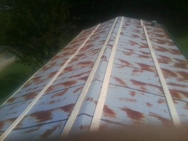 Rusted metal roof panels with new wood purlins before replacement — Storm Damage Roof Repair in Topton by Roofing Brothers