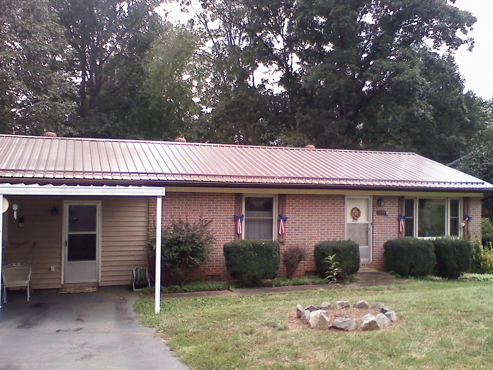 Bronze metal roof and carport on a brick ranch home — Roof Repair work by our crew in Topton