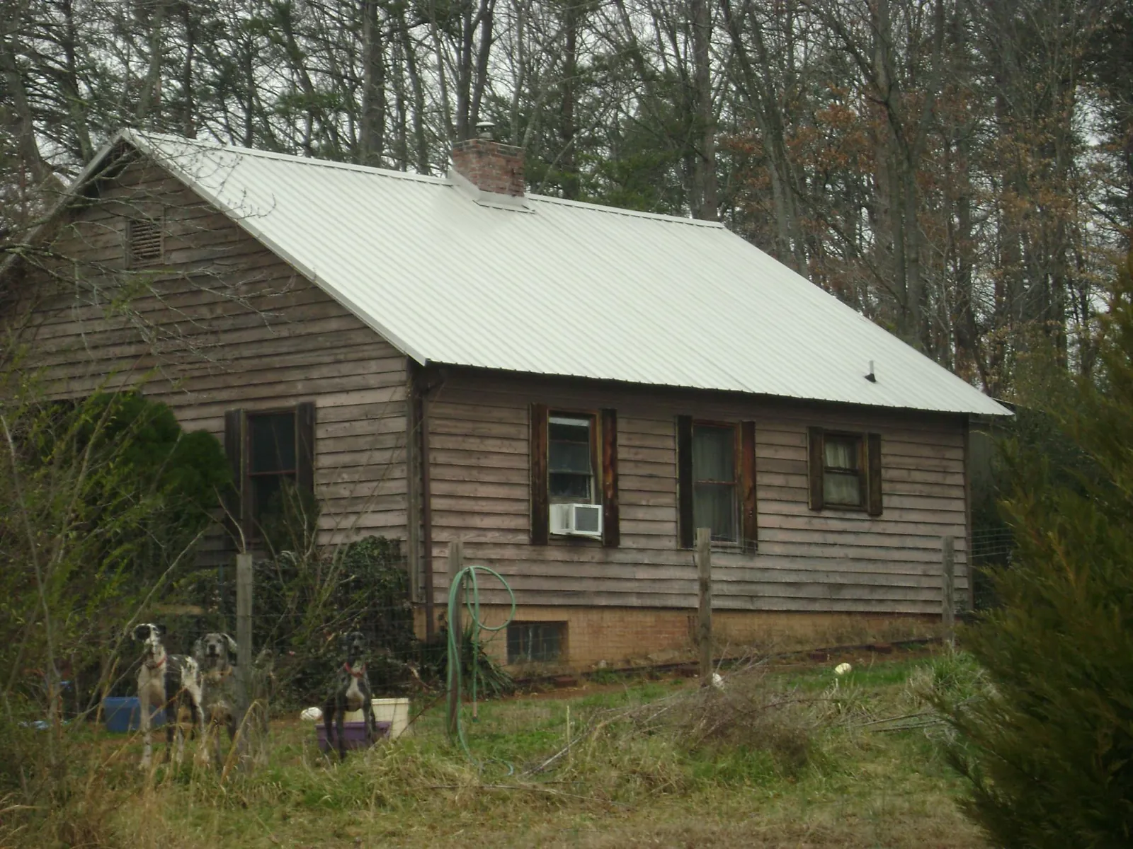 White metal roof on an old wood sided farmhouse, from a Metal Roof Installation job in Topton